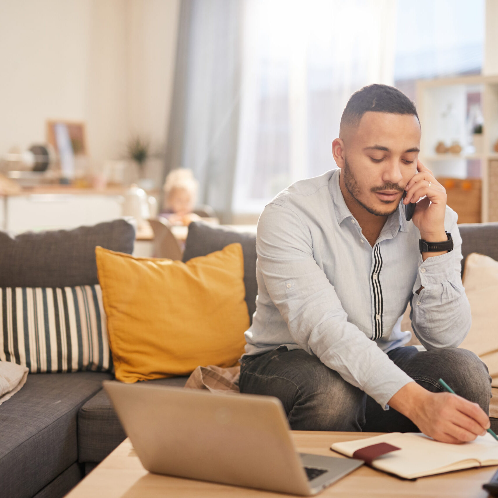 Portrait of modern mixed race man speaking by phone while working from home in cozy interior, copy space